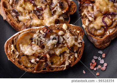 Delicious crispy toast or bruschetta with fried onion, champignon mushrooms and cheese 99328354