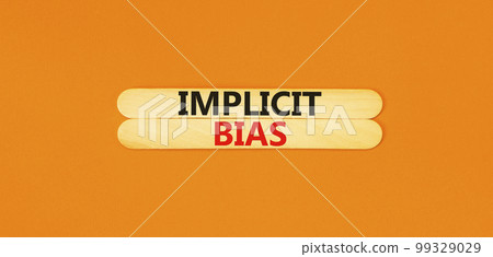 Implicit bias symbol. Concept words Implicit bias on wooden sticks. Beautiful orange table orange background. Business psychology implicit bias concept. Copy space. 99329029