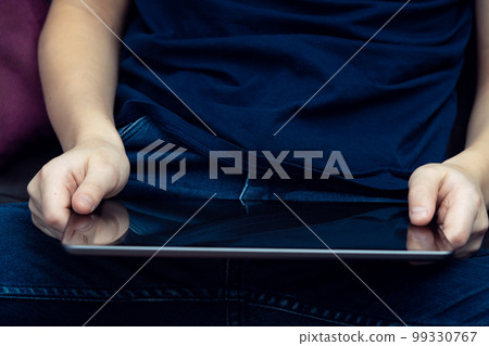 Unrecognizable midsection male hands holding digital tablet, sit with crossed legs. Elearning, application, market place 99330767