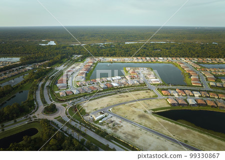 View from above of densely built residential houses under construction in closed living clubs in south Florida. American dream homes as example of real estate development in US suburbs View from above of densely built residential houses under construction in closed living clubs in south Florida. American dream homes as example of real estate development in US suburbs 99330867
