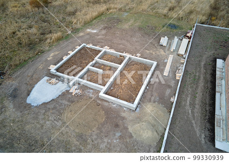 Top down aerial view of building works of new house concrete foundation on construction site Top down aerial view of building works of new house concrete foundation on construction site 99330939