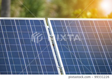 Solar photovoltaic panels mounted on stand-alone frame on backyard ground for generating of clean ecological electric energy. Concept of autonomous house Solar photovoltaic panels mounted on stand-alone frame on backyard ground for generating of clean ecological electric energy. Concept of autonomous house 99331226