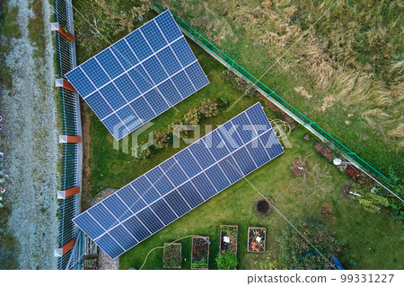 Solar photovoltaic panels mounted on stand-alone frame on backyard ground for generating of clean ecological electric energy. Concept of autonomous house Solar photovoltaic panels mounted on stand-alone frame on backyard ground for generating of clean ecological electric energy. Concept of autonomous house 99331227