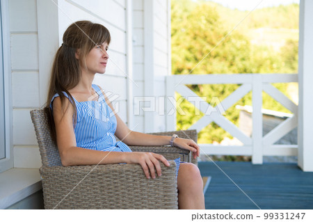 Attractive young woman relaxing on balcony. 99331247