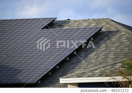 Residential house with rooftop covered with solar photovoltaic panels for producing of clean ecological electrical energy in suburban rural area. Concept of autonomous home 99331272