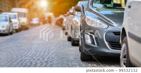 City traffic with cars parked in line on street side. 99332132