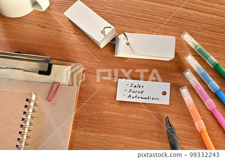 A desk with a vocabulary notebook that says Sales Force Automation 99332243