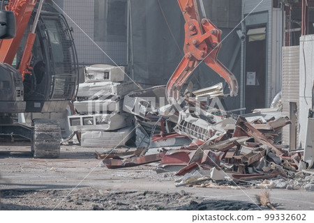 Heavy machinery processing scrap metal during store demolition work 99332602