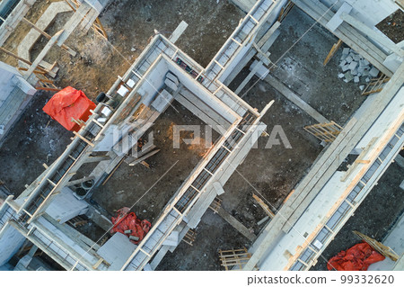 Aerial view of unfinished frame of private house foundation under construction. Aerial view of unfinished frame of private house foundation under construction. 99332620