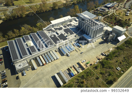 Aerial view of solar power plant with blue photovoltaic panels mounted on industrial building roof for producing green ecological electricity. Production of sustainable energy concept Aerial view of solar power plant with blue photovoltaic panels mounted on industrial building roof for producing green ecological electricity. Production of sustainable energy concept 99332649