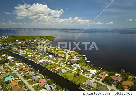 Aerial view of rural private houses in remote suburbs located on sea coast near Florida wildlife wetlands with green vegetation on gulf bay shore. Living close to nature in tropical region concept Aerial view of rural private houses in remote suburbs located on sea coast near Florida wildlife wetlands with green vegetation on gulf bay shore. Living close to nature in tropical region concept 99332705