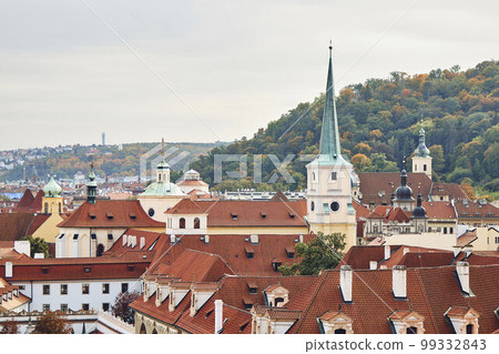 Orange tile roofs and church view, and historical buildings in Prague. 99332843