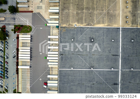 Aerial view of large commercial loading bay with many delivery trucks unloading and uploading retail goods for nationwide distribution. Global economy concept Aerial view of large commercial loading bay with many delivery trucks unloading and uploading retail goods for nationwide distribution. Global economy concept 99333124