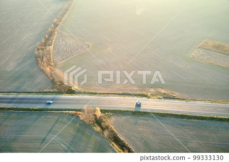 Aerial view of intercity road with fast driving cars at sunset. Top view from drone of highway traffic in evening 99333130