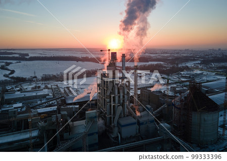 Aerial view of cement factory tower with high concrete plant structure at industrial production area at sunset. Manufacturing and global industry concept Aerial view of cement factory tower with high concrete plant structure at industrial production area at sunset. Manufacturing and global industry concept 99333396