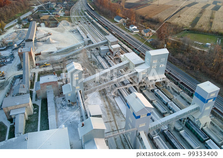Aerial view of cargo train loaded with crushed stone materials at mining factory. Railway transportation of grinded limestone ore Aerial view of cargo train loaded with crushed stone materials at mining factory. Railway transportation of grinded limestone ore 99333400