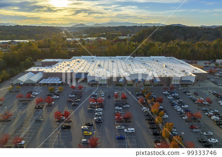 Aerial view grocery shopping mall and many colorful cars parked on parking lot with lines and markings for parking places and directions. Place for vehicles in front of a strip mall plaza 99333746