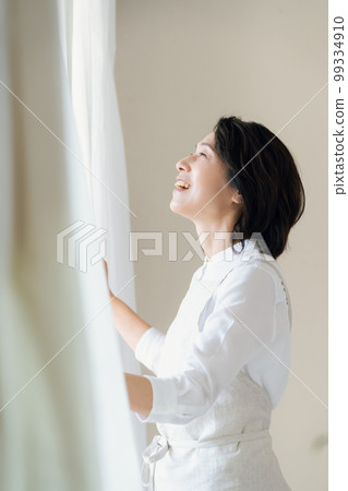 Middle woman opening the curtain Middle woman opening the curtain 99334910
