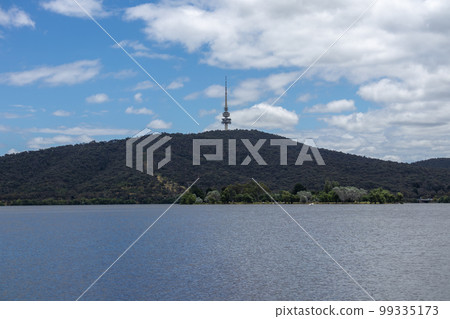 Photograph of a large telecommunications tower on a hill across water Photograph of a large telecommunications tower on a hill across water 99335173