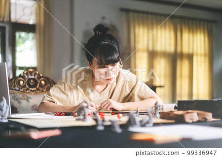 Young adult asian woman enjoying role playing tabletop and board game Young adult asian woman enjoying role playing tabletop and board game 99336947