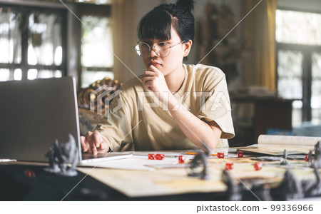 Young adult asian woman enjoying role playing tabletop and board game Young adult asian woman enjoying role playing tabletop and board game 99336966