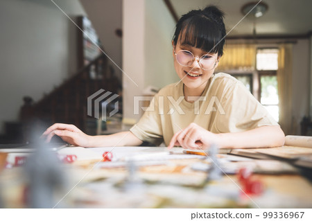 Young adult asian woman enjoying role playing tabletop and board game Young adult asian woman enjoying role playing tabletop and board game 99336967