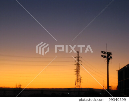 A photo of a high-voltage steel tower and high-voltage lighting shining in the evening sun. A photo of a high-voltage steel tower and high-voltage lighting shining in the evening sun. 99340899