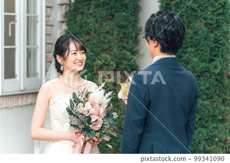 Bride and groom with a bouquet in the garden of the wedding hall at the wedding ceremony (garden wedding) 99341090