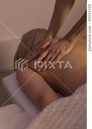 Male masseur, therapist doing professional therapeutic massage on the back of white woman, kneading muscles of client in spa salon. Mental, health sustainability. Relaxation, healthcare. Vertical Male masseur, therapist doing professional therapeutic massage on the back of white woman, kneading muscles of client in spa salon. Mental, health sustainability. Relaxation, healthcare. Vertical 99343209
