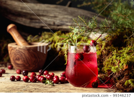 Cranberry cocktail with natural ice and rosemary in frozen glass. 99346237