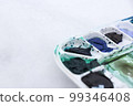 Part of white palette with watercolors on light blurred background, horizontal photo. 99346408