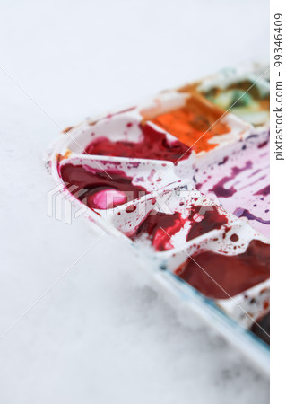 Part of white palette with watercolors on light blurred background, horizontal photo. Part of white palette with watercolors on light blurred background, horizontal photo. 99346409