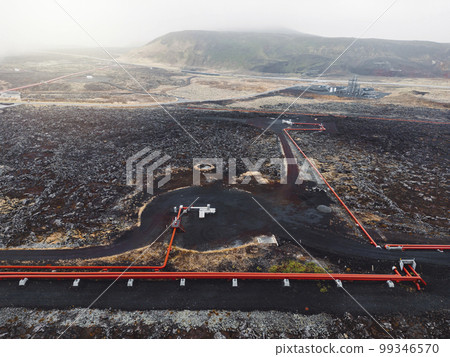 Aerial view of red pipes running on the black volcanic grounds in Iceland 99346570
