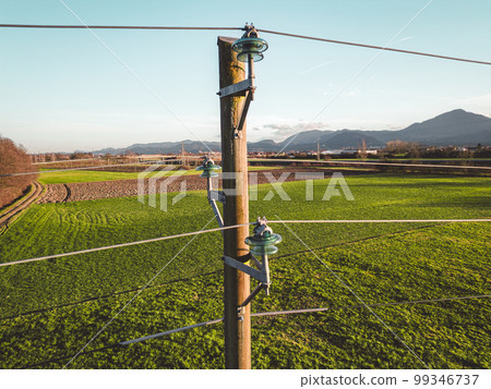 Close up of an old electrical tower with electrical wire running to and from it Close up of an old electrical tower with electrical wire running to and from it 99346737