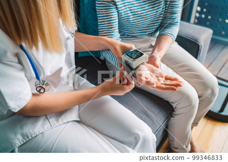 Top down vie unrecognizable nurse measuring her patients blood pressure  99346833