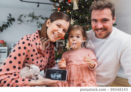 Loving family of three announces a new baby on the way on the Christmas day Loving family of three announces a new baby on the way on the Christmas day 99348143