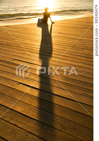 Woman bathing in the sunset on the beach 99348474