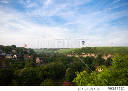 Kamianets-Podilskyi, Ukraine. Colorful balloons flying over a beautiful medieval castle, a very beautiful view of the city. Ballooning for tourists. 99348581