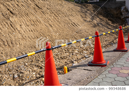 一個三角錐守衛著為重建房屋而清理的土地。 一個三角錐守衛著為重建房屋而清理的土地。 99348686