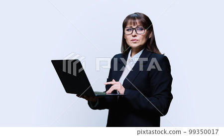 Mature business woman posing with laptop on white background Mature business woman posing with laptop on white background 99350017