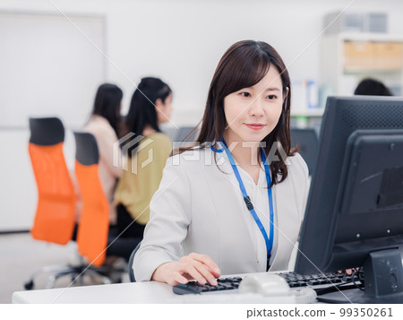 A woman doing desk work with a smile A woman doing desk work with a smile 99350261