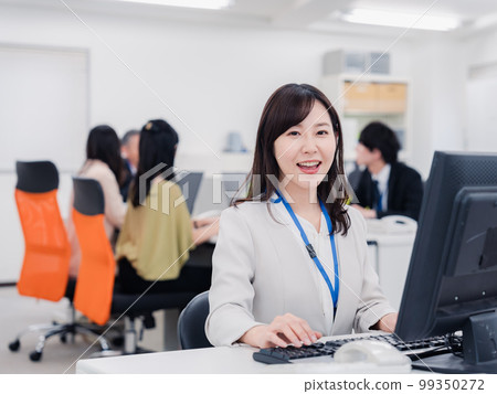 A woman doing desk work with a smile A woman doing desk work with a smile 99350272