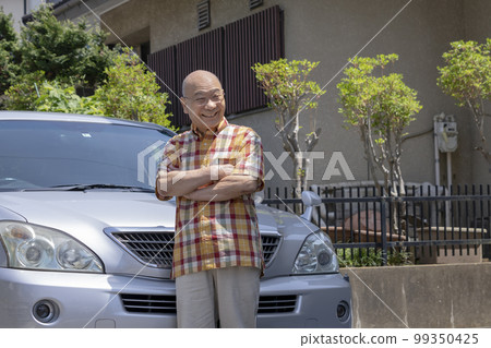 70 多歲的男人在他的家庭肖像前微笑 70 多歲的男人在他的家庭肖像前微笑 99350425