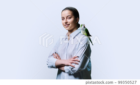 Young teenage female with green pet parrot, on white background 99350527