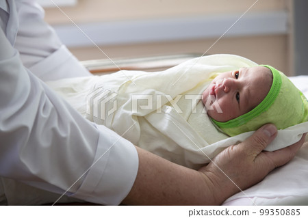 Medical staff caring for a newborn in the hospital. 99350885