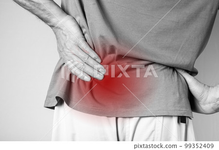 Man suffering from lower back pain. Backache with red spot closeup. Sedentary lifestyle, chronic health problems concept. Muscles spasm 99352409