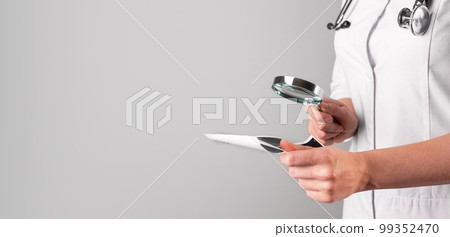 Medical research concept. Doctor hand holding magnifying glass, studying document, scan. Banner, background for text 99352470