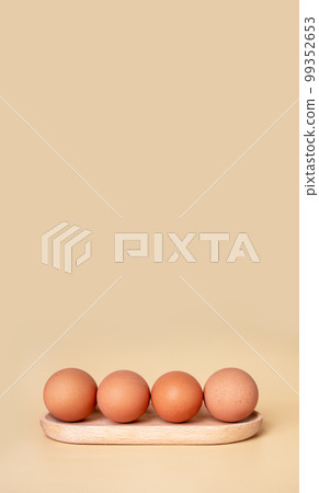 Banner with boiled eggs at wooden server. Easter concept. Copyspace on beige background. Nutritious farm product. 99352653
