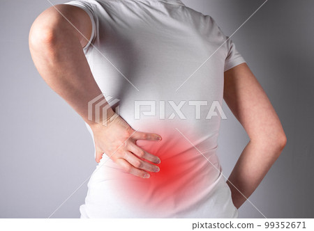 Backache. Woman suffering from lower back pain with red spot closeup. Muscle spasm, sprains, strains, inflammation. Sport, household injury, nervous diseases. Health care and medicine concept 99352671