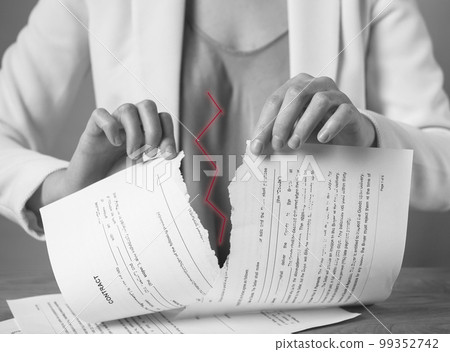Torn document in hands. Breaking contract. Sanctions, agreement conditions and rules breaching, force majeure. Woman ripping paper agreement. Black and white Torn document in hands. Breaking contract. Sanctions, agreement conditions and rules breaching, force majeure. Woman ripping paper agreement. Black and white 99352742